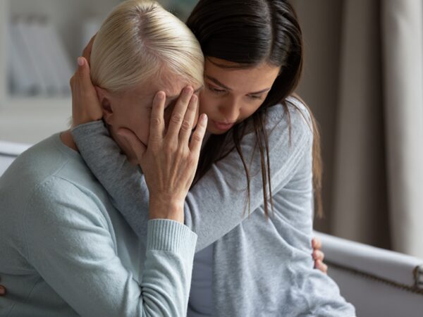 Young woman consoling upset older woman